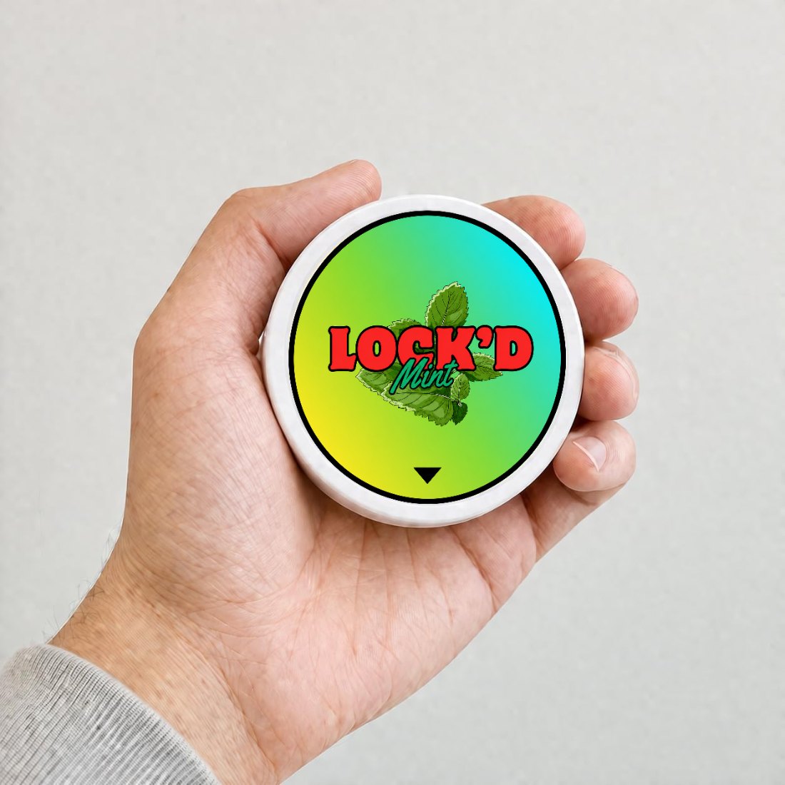 A hand holding a LOCK'D Mint tin, showing its pocket size